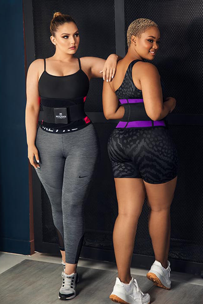 Dos mujeres con cinturillas deportivas Moldeate en atuendo fitness, posando en ambiente interior.